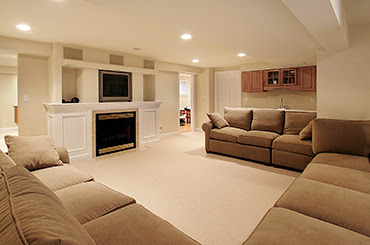 basement room with tv and three sectional couches